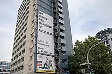 An einem Hochhaus wurde ein Plakat montiert.