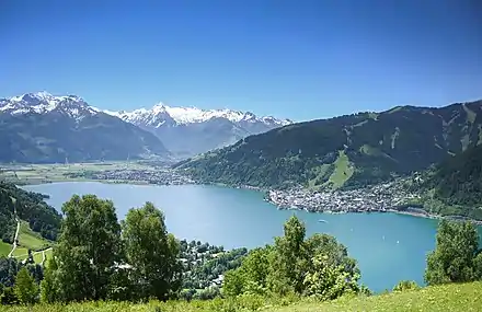 rechts Zeller Altstadt, links Zell am See-Süd, vorne Thumersbach; vom Mitterberg, Richtung Südwesten über Zeller See gegen Hausberg Schmittenhöhe, und über Salzachtal gegen Kitzsteinhorn